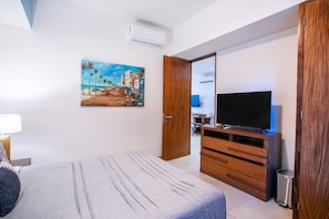 Une chambre d’hôtel avec un lit, une télévision, un tableau et une armoire.