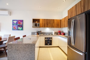 Enjoy cooking in this well-equipped kitchen with a large island, oven, and stainless steel appliances.