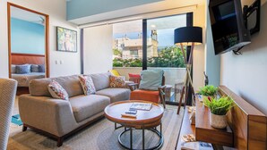 A modern living room with a sofa, coffee table, and a TV mounted on the wall.