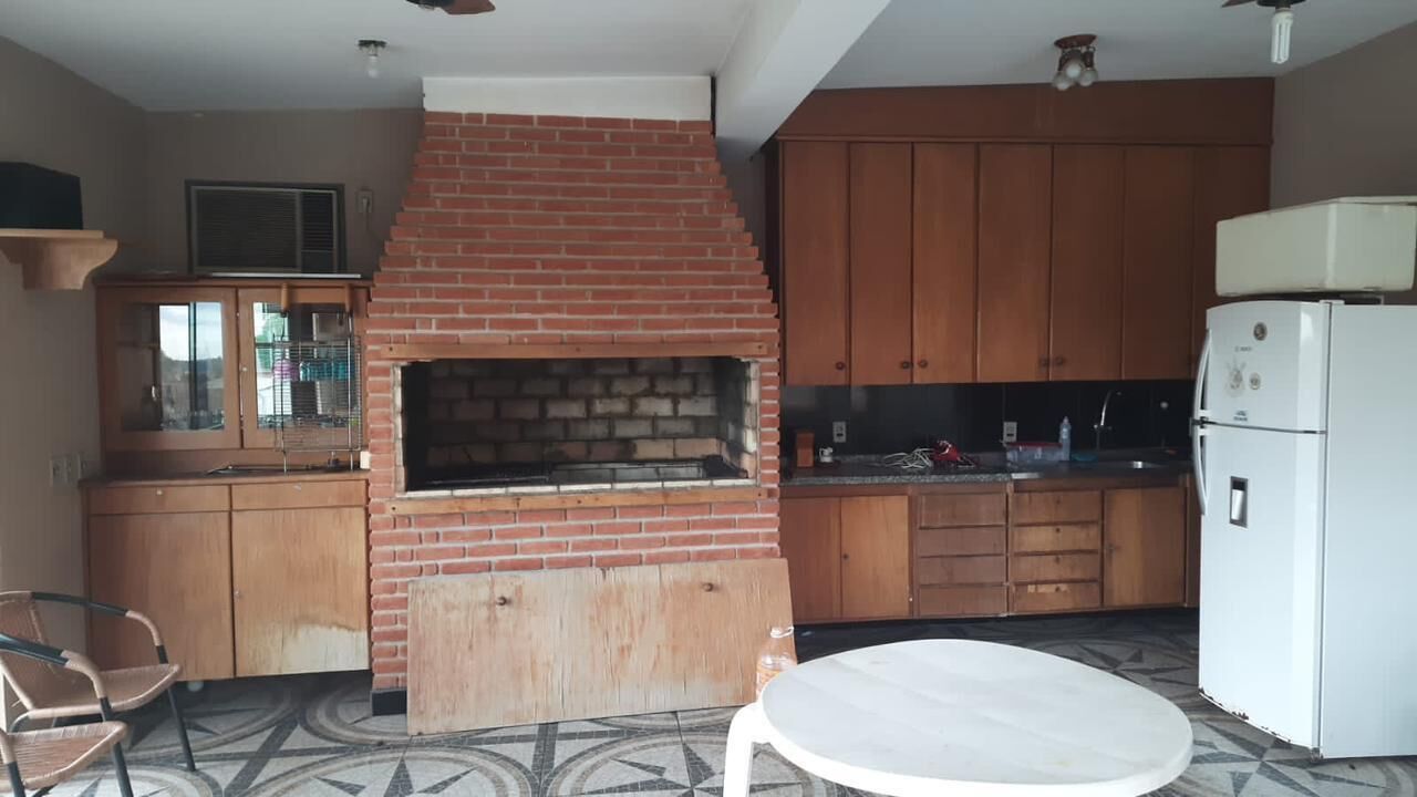 Eine Küche mit Backofen, Holzschränken und einem weißen Kühlschrank.