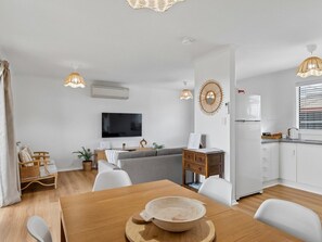 A modern living space with a dining area, kitchen, and seating area. - Coastal Break - Family Escape in Port Hughes (Port Hughes)