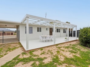 A single-story house with a covered patio area, a fenced yard, and a small garden. - Coastal Break - Family Escape in Port Hughes (Port Hughes)