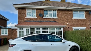 A white car parked in front of a brick house with a tiled roof. - Sandringham House Serene Escape Cottage (Cleethorpes)