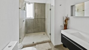 A modern bathroom with a glass-enclosed shower, a white sink, and a black vanity. - 113-B201 Luxury 3br/2.5 baths in Condesa (Mexico City)