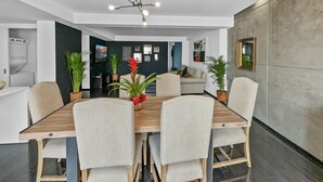 A modern dining area with a wooden table and four chairs, a ceiling fan, and potted plants. - 113-B201 Luxury 3br/2.5 baths in Condesa (Mexico City)