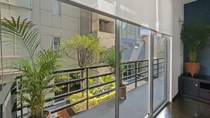 A modern interior with a glass balcony, potted plants, and a view of the outside building. - 113-B201 Luxury 3br/2.5 baths in Condesa (Mexico City)