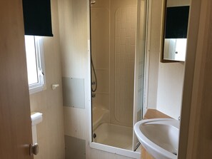 A bathroom with a shower, a sink, and a mirror.