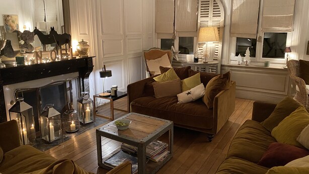 Una sala de estar acogedora con chimenea, un conjunto de sofás y una mesa de centro.