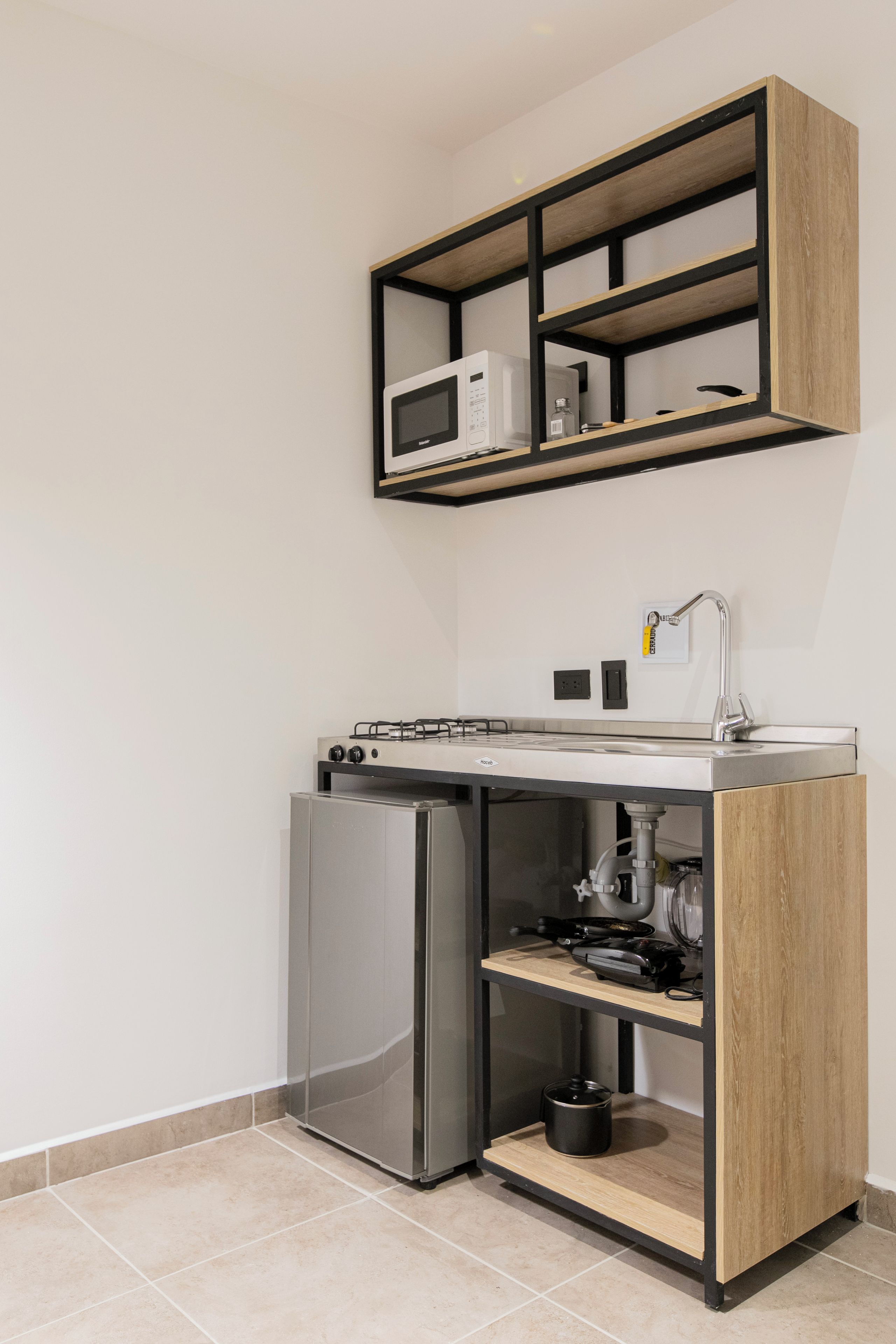 A compact kitchen with a built-in microwave, a gas stove, and a refrigerator.