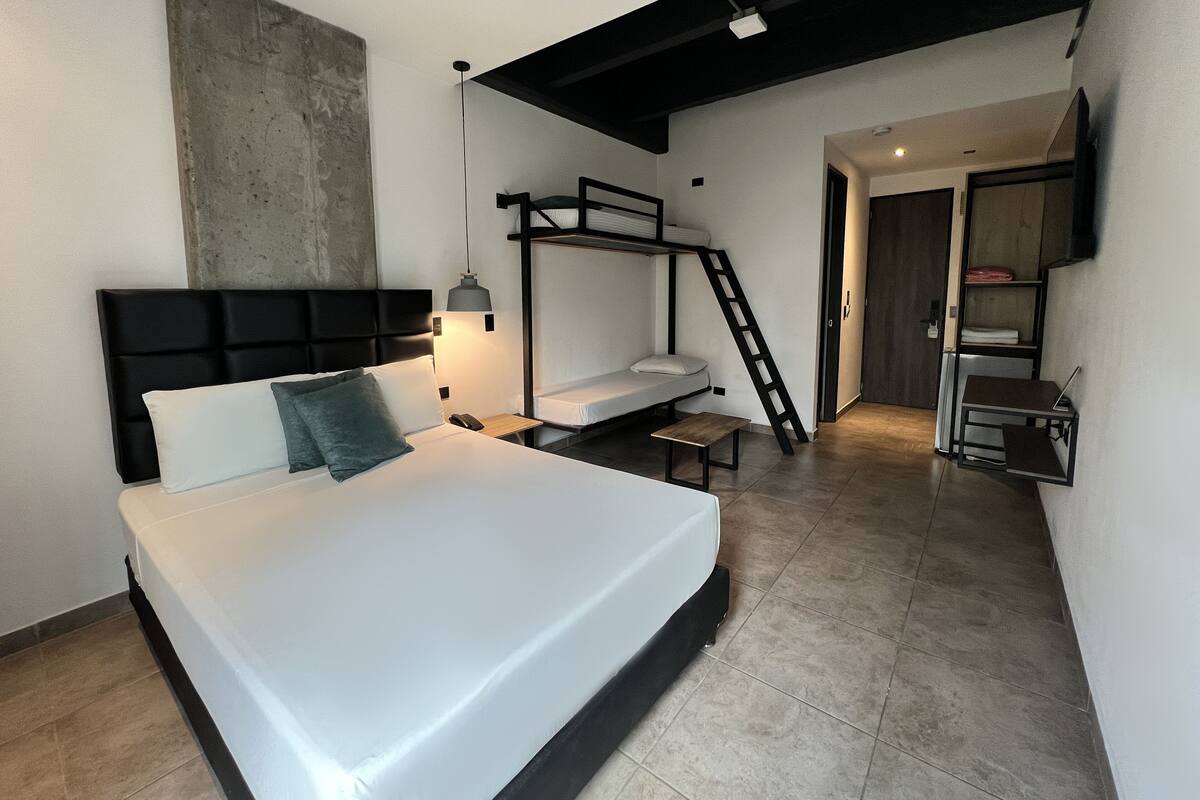 Un dormitorio moderno con una cama litera, un escritorio y una escalera.