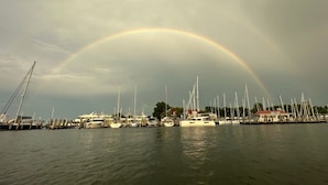 Een jachthaven met boten die onder een regenboog liggen aangemeerd.