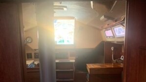 Een kleine kamer met een stapelbed, een bureau en een klein raam.