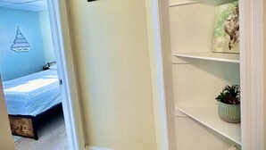 A bedroom with a bed, a star-shaped picture frame, a shelf with decorative items, and a wall with a 'Beach Relax' sign. - Bright and spacious condo, a short walk to the beach, boardwalk and amusements.  (Wildwood)