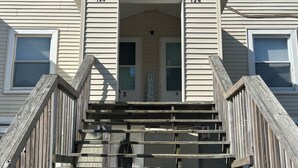 A building with a set of wooden stairs leading to a door marked with the number 124. - Bright and spacious condo, a short walk to the beach, boardwalk and amusements.  (Wildwood)