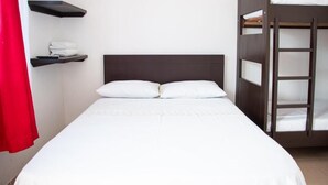 A single bed with white bedding, a dark headboard, and a red curtain to the left. - Santo Domingo Centro Vacacional (Jerusalén)