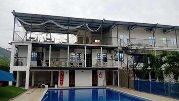 A two-story building with a swimming pool in front.