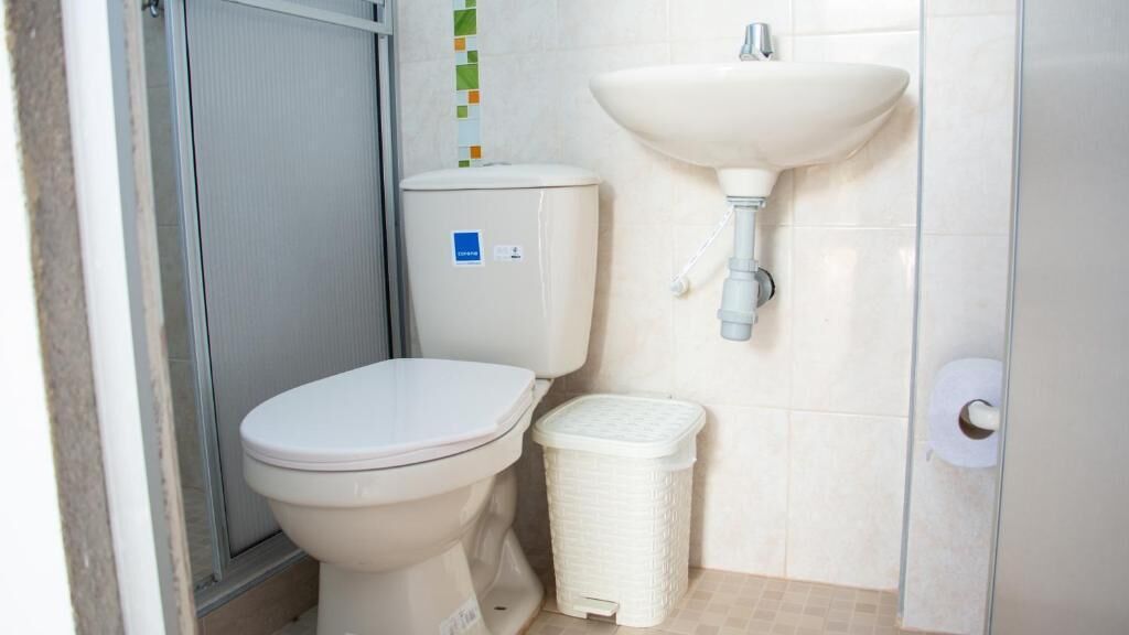 Ein Badezimmer mit Toilette, Waschbecken und Mülleimer.