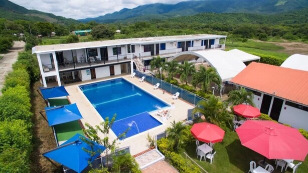 A hotel with a swimming pool, outdoor seating, and a view of the mountains. - Santo Domingo Centro Vacacional (Jerusalén)