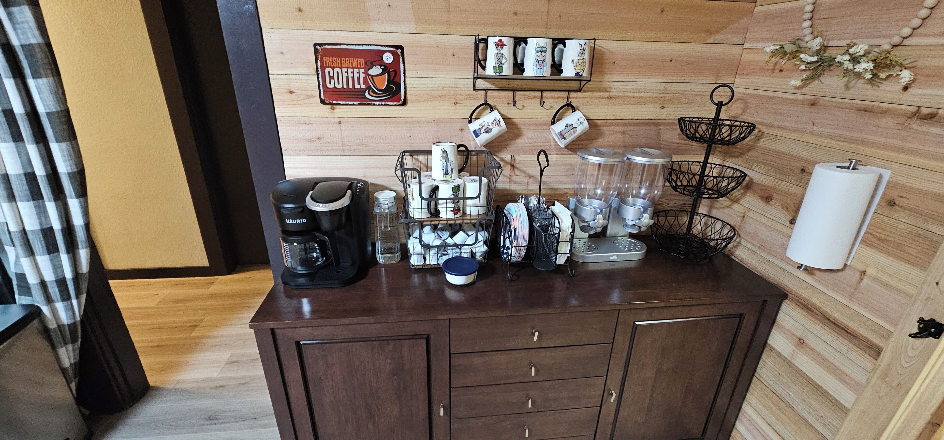 A coffee station with a Keurig coffee maker, mugs, and a coffee grinder.