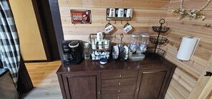 A coffee station with a Keurig coffee maker, mugs, and a coffee grinder. - The Canna House by High Society Rentals (Clovis)