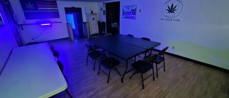 A conference room with a long table and chairs, a door, and a wall with a logo and text.