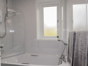 A bathroom with a bathtub, a shower, and a window. - Taigh Neilag (Strath)
