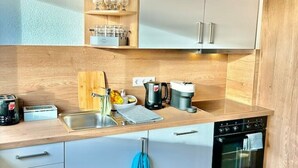 A modern kitchen with a wooden countertop, a coffee maker, a kettle, and a toaster. - Diamond Apartments: Dreiländereck Nahe Flughafen (Rheinfelden (Baden))