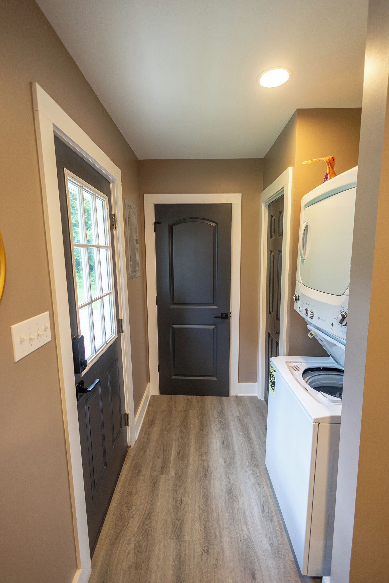 A laundry room with a washing machine, a dryer, and a door leading to another room.