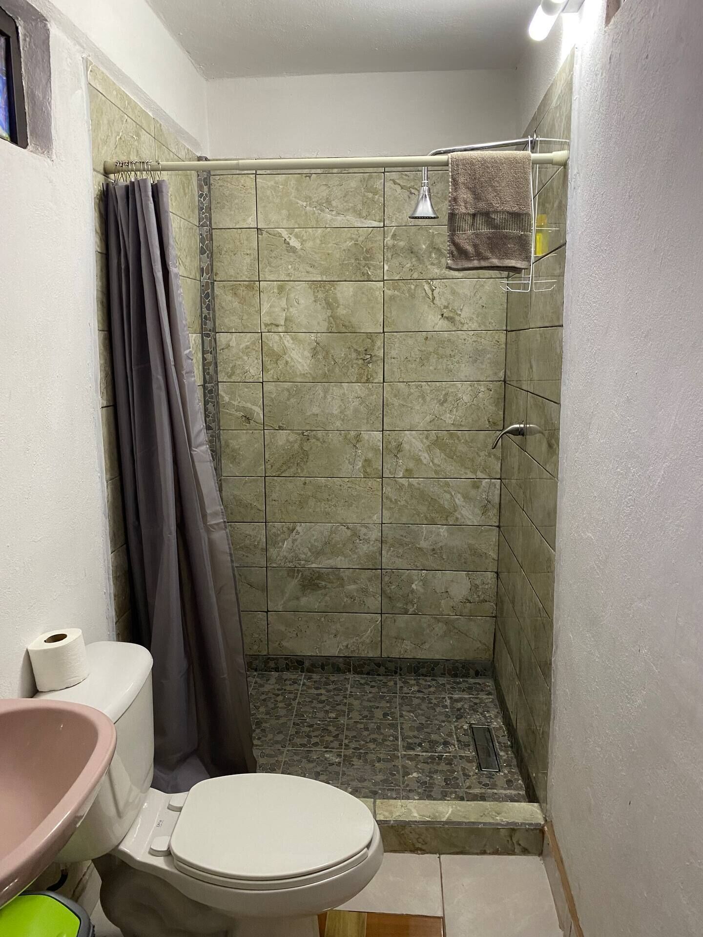 A bathroom with a shower, toilet, and sink.