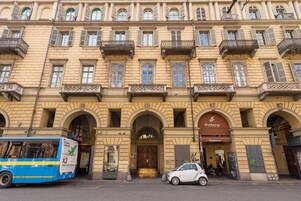 Ein historisches Gebäude mit mehreren Balkonen, einem zentralen Eingang mit einer Tür und einem Schild mit der Aufschrift 'Sant'Angelo'.