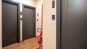 Un couloir avec deux portes, numérotées 406 et 405, et un extincteur fixé au mur.