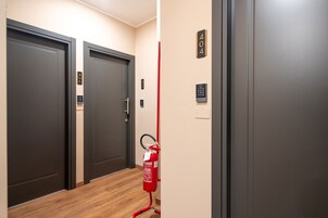 Ein Flur mit zwei Türen, mit den Nummern 406 und 405, und einem an der Wand befestigten Feuerlöscher.