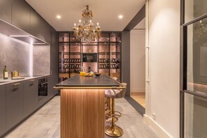 A modern kitchen with a central island, a wine rack, and a chandelier. - Luxury 3-Bed Apartment in Salamanca, Madrid (Madrid)