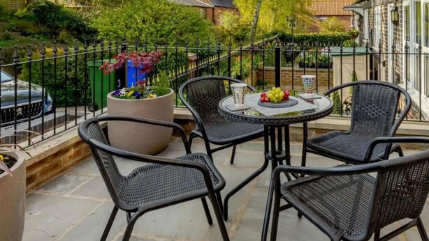 A balcony with wicker chairs, a table, and potted plants. - Stunning 2-bed House in Walkington Near Beverley (Beverley)