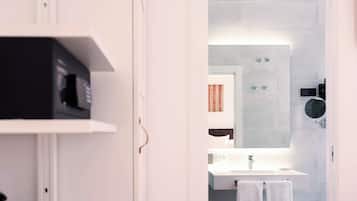 A modern bathroom with a white sink, a mirror, and a towel rack.