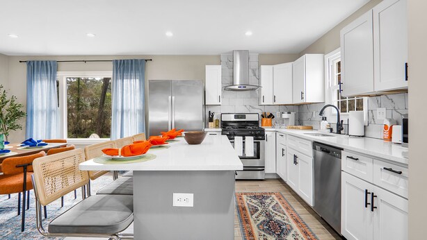 A modern kitchen with white cabinets, stainless steel appliances, and a central island. - 5bd Vibrant Haven: Basketball - 10mins to Airport (Charlotte)