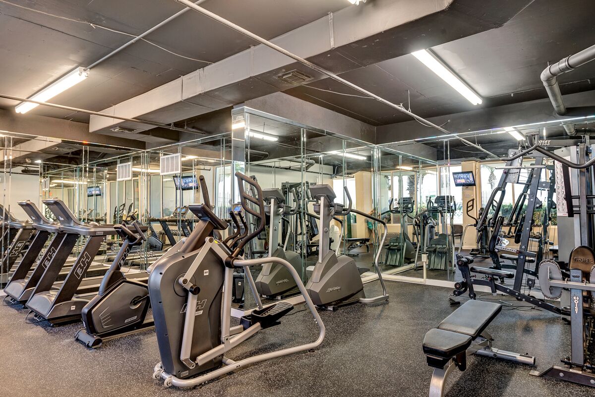 Ein Fitnessstudio mit Laufbändern, Crosstrainern und Gewichtsmaschinen.