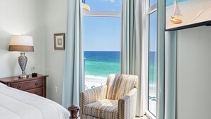 A bedroom with a large window offering a view of the beach and ocean. - Sunset Views, Gulf Front at Jade East Towers (Destin)