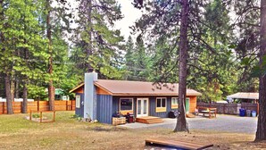 A cabin with a chimney, a fire pit, and outdoor seating. - Cozy home on private acreage,
 with a short walk to downtown Leavenworth. (Leavenworth)