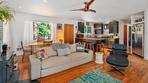 A modern living room with a sofa, a dining table, and a kitchen area. - Cozy home on private acreage,
 with a short walk to downtown Leavenworth. (Leavenworth)