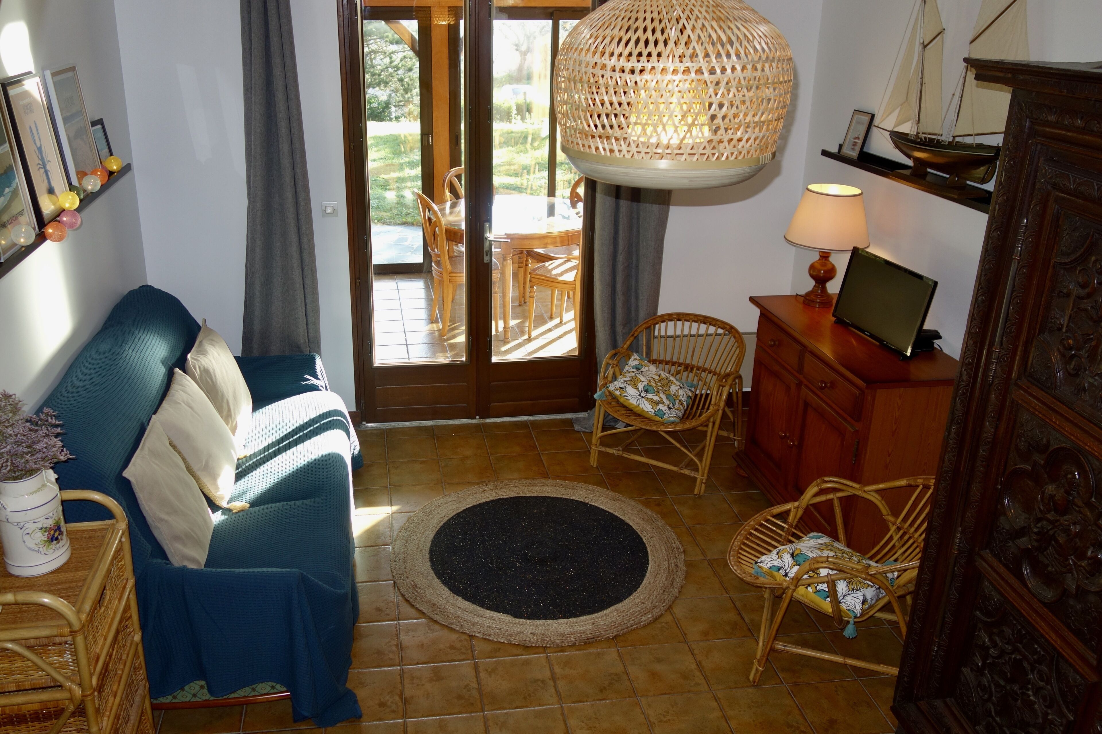 A living room with a sofa, chairs, a lamp, and a dining table with chairs.
