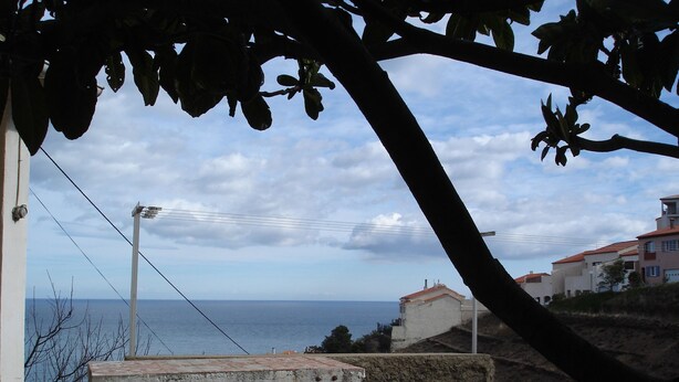 A coastal view with a bench, a stone wall, and buildings in the background. - Studio a Cerbere au Calme (Cerbère)