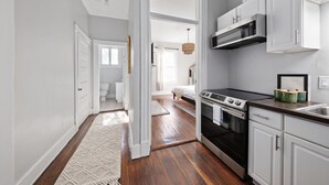 Una cocina moderna con armarios blancos, una estufa negra y un fregadero de acero inoxidable.