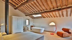 Une salle de bain moderne avec une baignoire sur pieds, un meuble blanc et un lampadaire rouge.