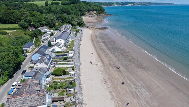 A coastal town with a sandy beach, residential buildings, and a clear view of the sea. - The Beachhouse - 2 Bed Townhouse - Saundersfoot (Saundersfoot)