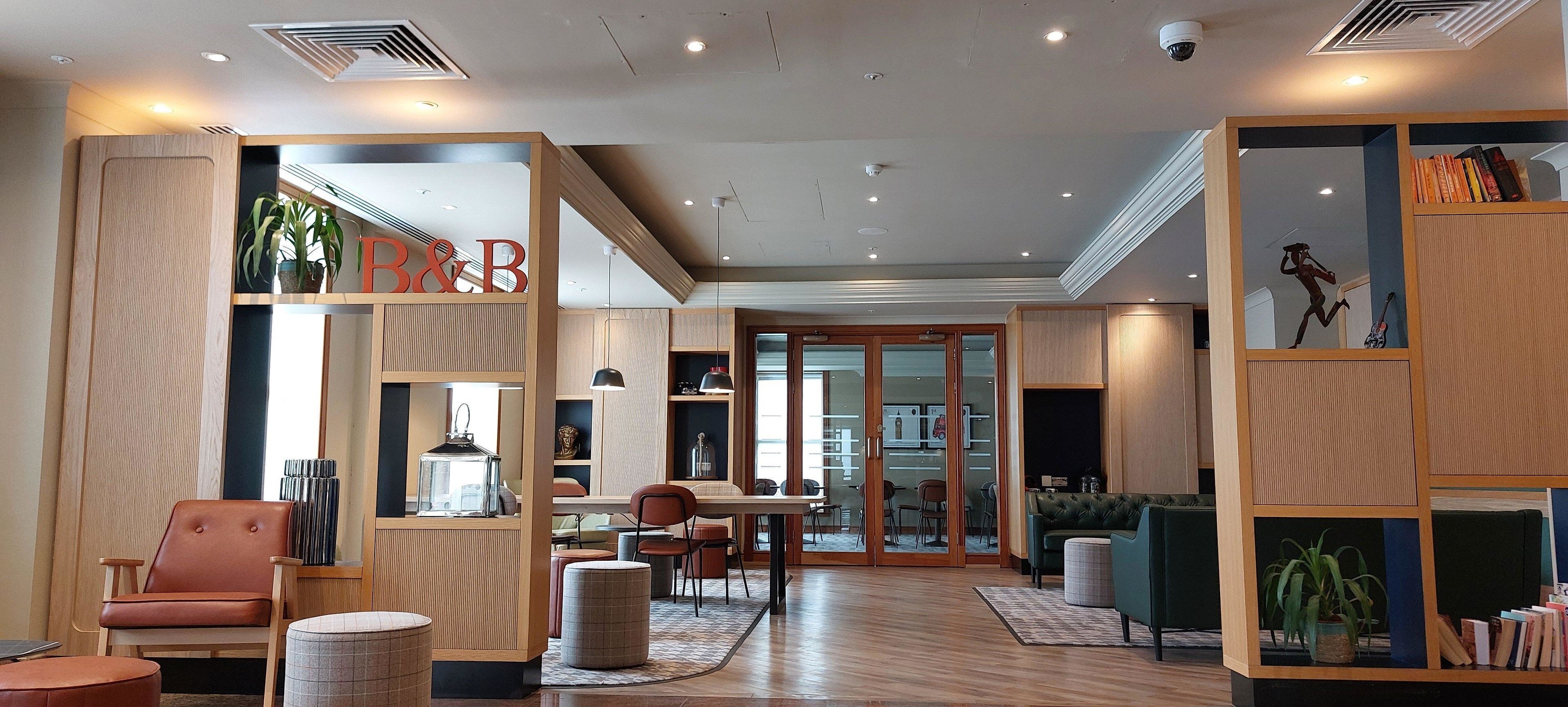Ein modernes Interieur mit einer Rezeption, einer Sitzecke und einem Bücherregal.