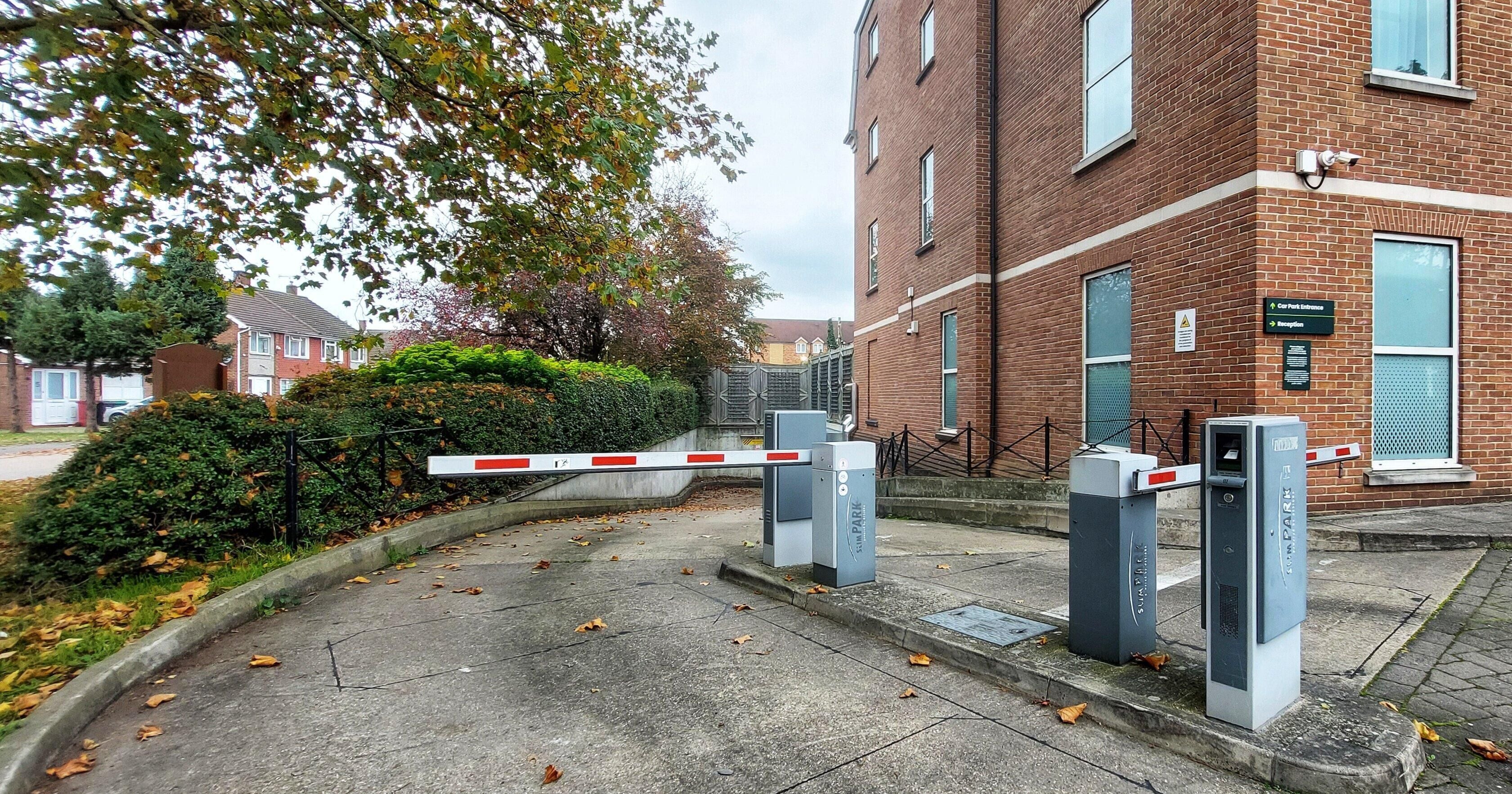 Een hek sluit de opgang naar een wooncomplex in, met een duidelijk pad naar de ingang.