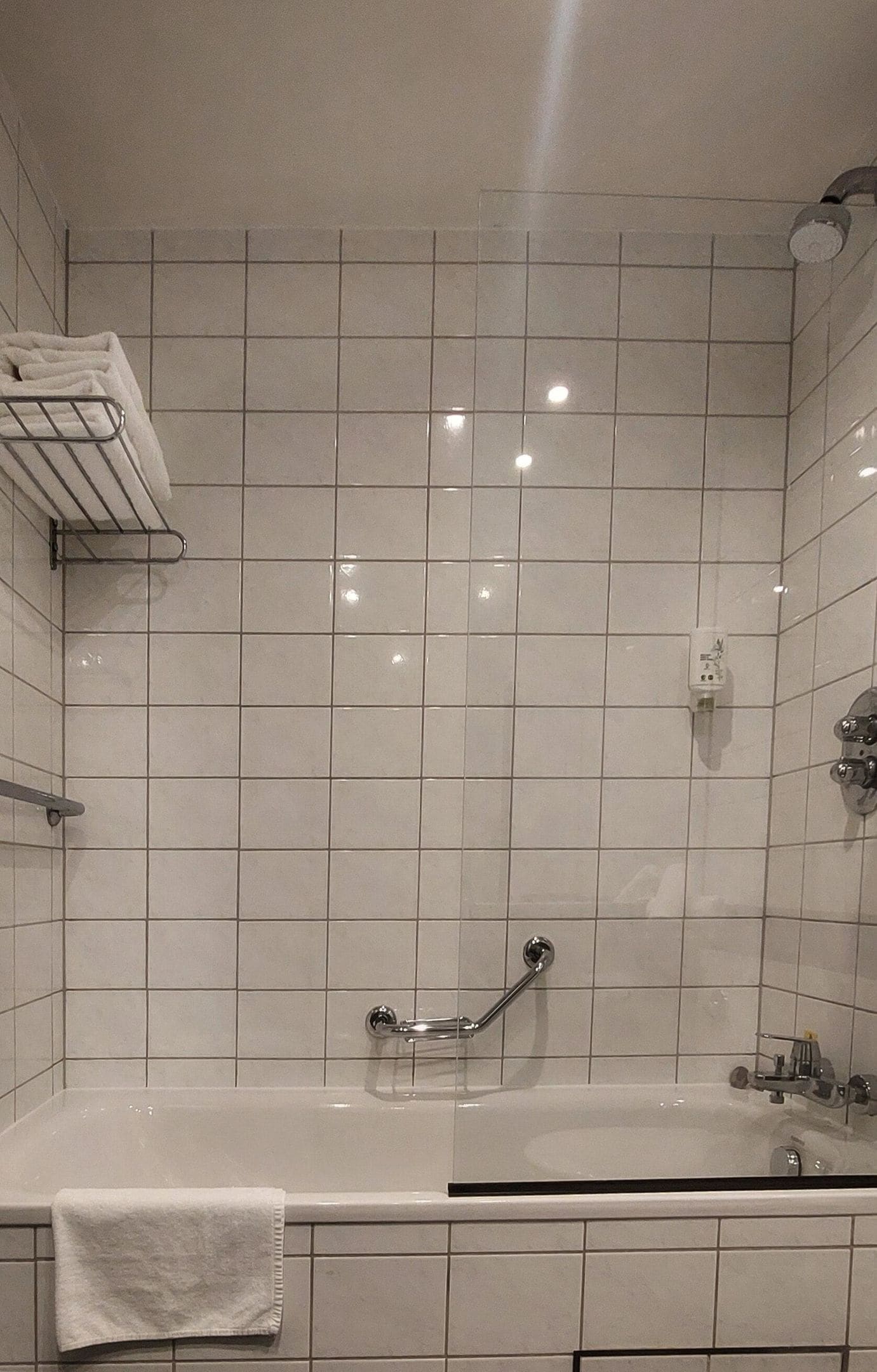 Ein modernes Badezimmer mit Badewanne, Dusche und Handtuchhalter.