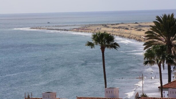 A coastal view with a beach, palm trees, and a pier. - Alsol Las Perlas (San Bartolomé de Tirajana)