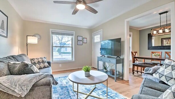 A living room with a ceiling fan, a TV, a dining area with a table and chairs, and a large window. - Walk to FIFA World Cup! 1mi to AT&T Stadium - Texas Live! - GlobeLife Field. (Arlington)